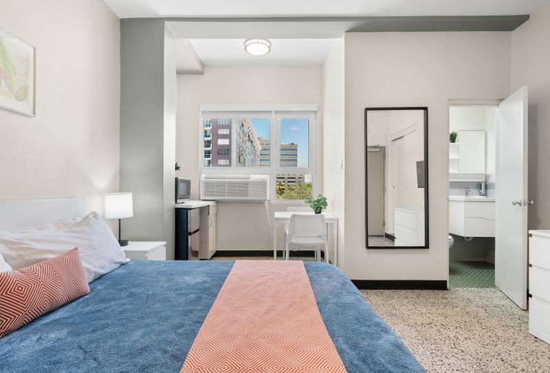 This functional yet comfortable space offers a cozy bed, ample storage, and a small table, perfect for catching up on work or enjoying a quiet meal.