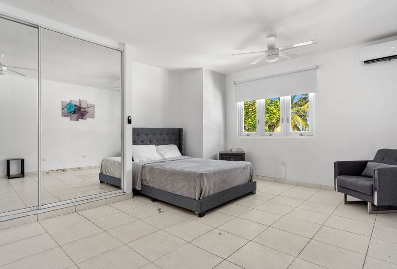 Morning light pours into this minimalist bedroom, fostering a serene, airy ambiance.