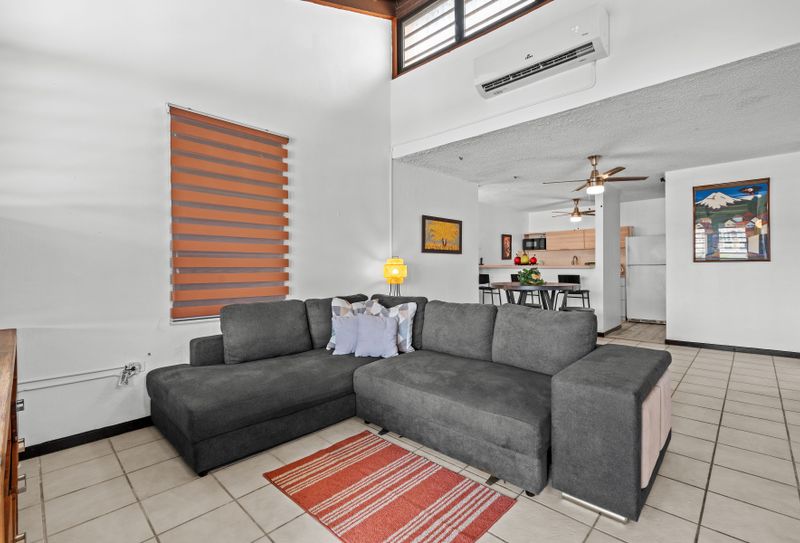 Unwind in our spacious living room featuring a plush gray sectional sofa, perfect for relaxing or enjoying a movie night.