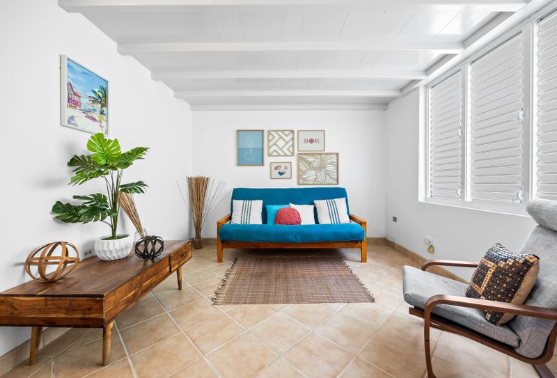 Sun-filled living room with a comfy couch and large windows – great for lounging and relaxing.