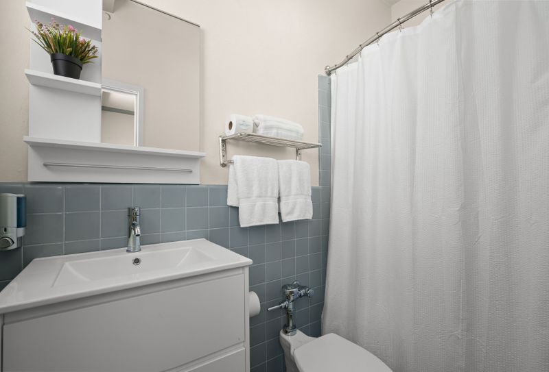 Refresh and rejuvenate in our immaculate bathroom, boasting fresh towels, essential toiletries, and a clean, spacious vanity for your convenience.
