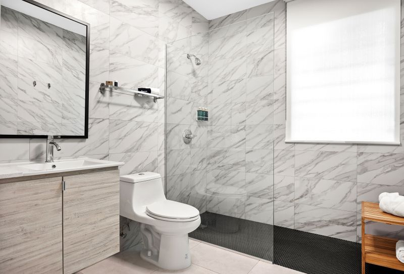 This functional bathroom includes a toilet, sink, and shower.