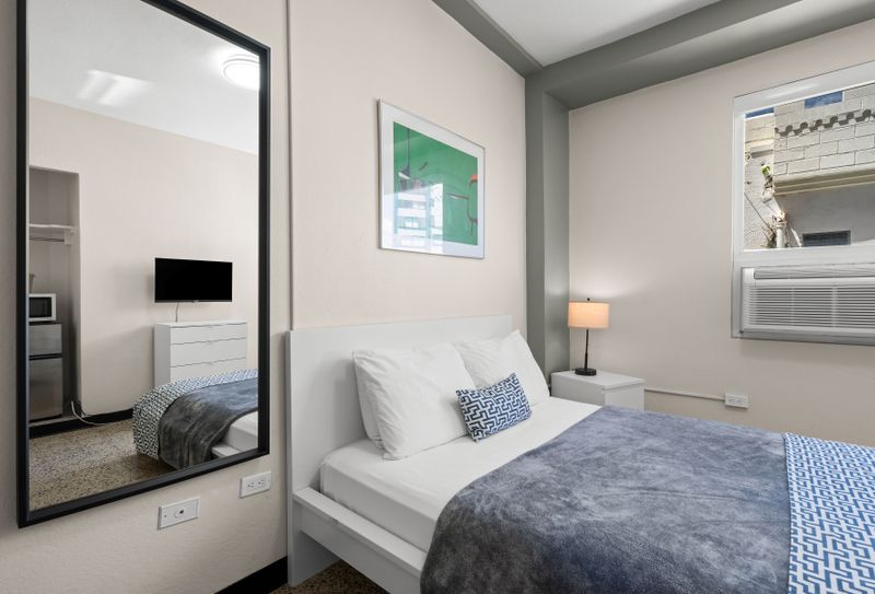 Drift into a peaceful slumber in our beautifully appointed bedroom featuring a plush queen-sized bed, crisp linens, and soft lighting for ultimate relaxation after a day of exploring.