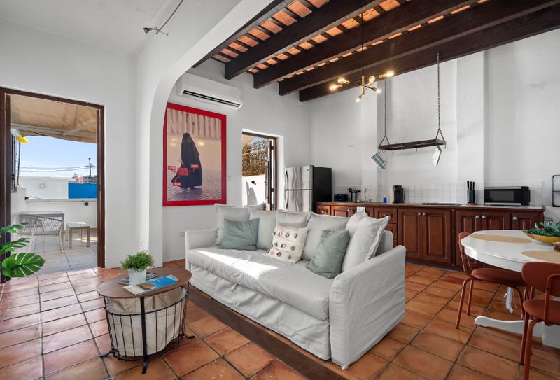 spacious living room with balcony terrace, kitchen with microwave and fridge, dining table with 5 seats and coffee table