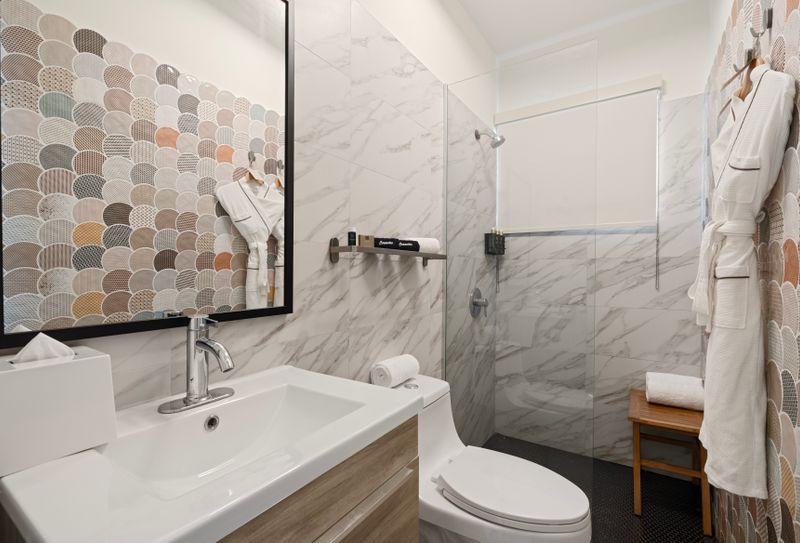 A plush bathrobe hangs neatly beside a vanity mirror, while bath essentials sits ready to pamper.