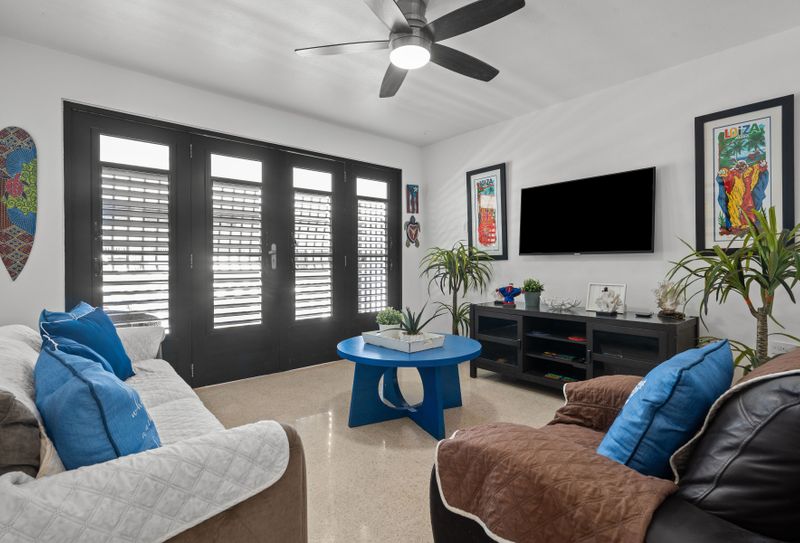 Serene Slumber: Drift off to sleep in this peaceful bedroom, featuring comfortable bedding and charming dark shutters for a perfect night's rest.