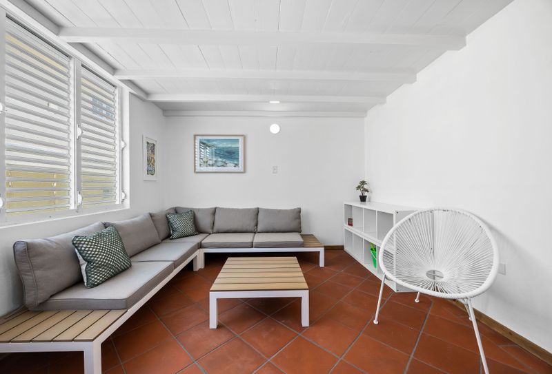 Rincón | Stay With Balcony 2 Relax in style in this inviting living room. Featuring a comfortable sectional sofa, perfect for lounging, and a stylish coffee table, this space is designed for both comfort and conversation.