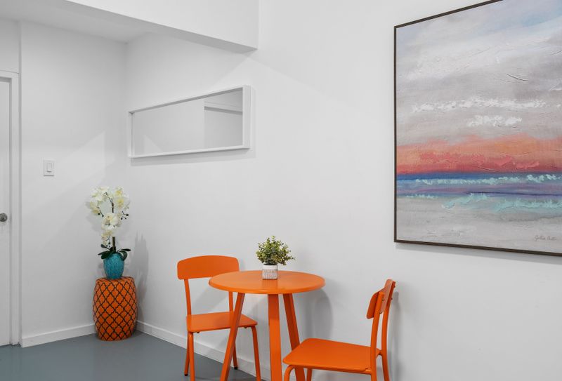 Cheerful living room featuring an orange table and chairs, ideal for socializing or relaxing.