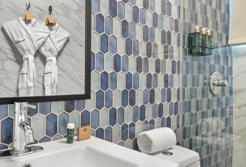 Indulge in a spa-like experience with our luxurious bathroom, featuring a stunning mosaic tile design.