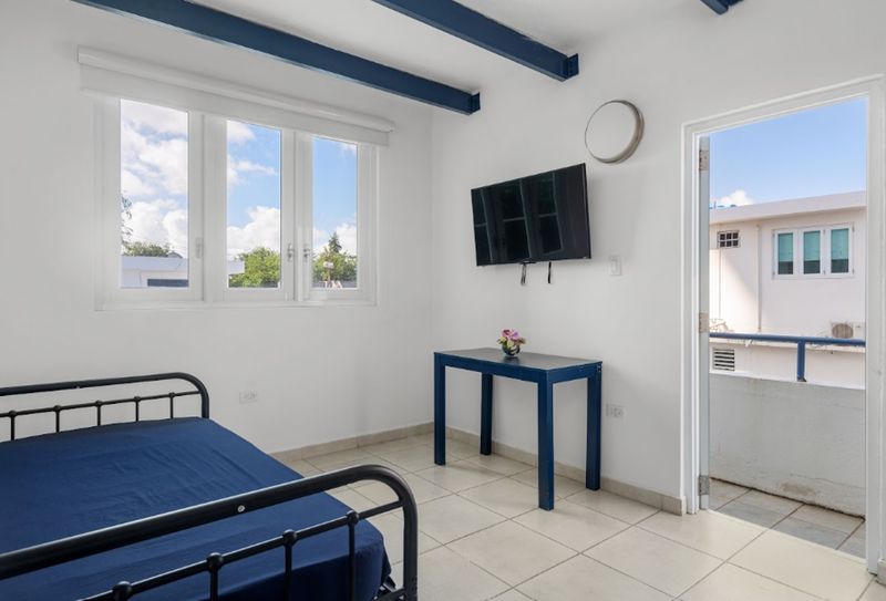 Enjoy the simplicity and comfort of this bright, airy room with a cozy bed, modern entertainment system, and easy access to the peaceful outdoors.