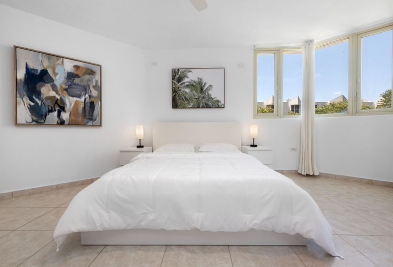 Plush pillows and silky linens transform this bedroom into the perfect cozy retreat.
