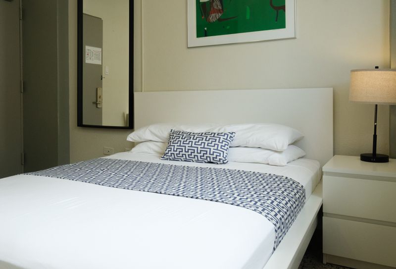 Luxury and comfort combined. This spacious bedroom features an opulent queen bed with extra pillows, inviting you to sink in and enjoy a truly relaxing experience.