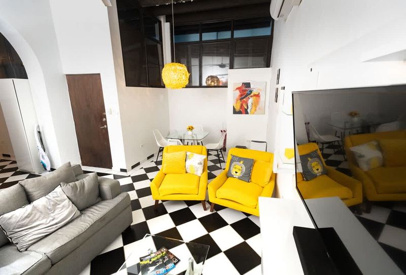 Old San Juan | Vibrant and Modern Stay 3 Experience vibrant comfort in this inviting living room. With a large grey sofa, cheerful yellow cushions, and two additional seats, there's ample space for everyone to gather. Enjoy entertainment on the smart TV in this lively and welcoming space.