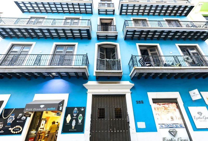 Old San Juan | Vibrant and Modern Stay 5 Welcome to a piece of history. This stunning building, showcasing classic Spanish colonial design and elegant wrought iron work, provides a picturesque backdrop for your unforgettable visit.