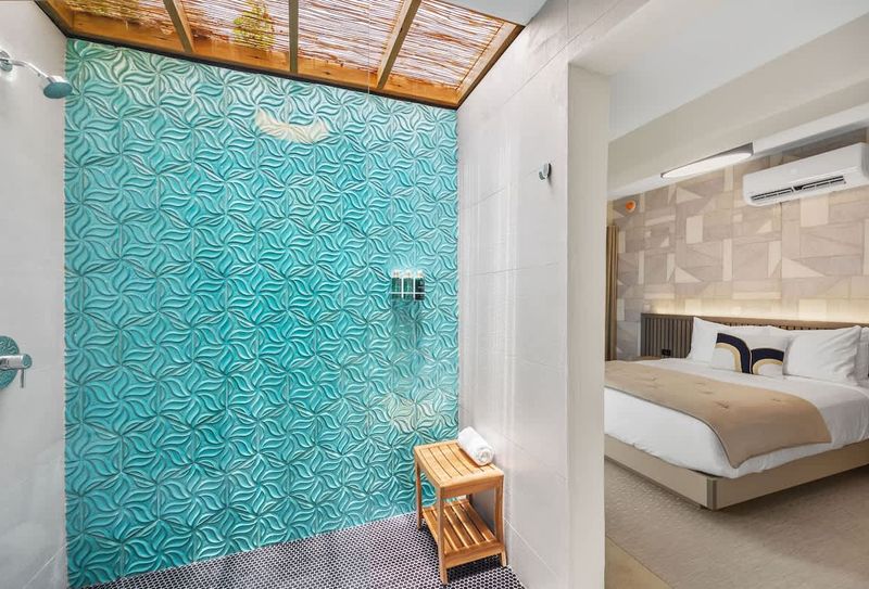 Cozy integrated living space featuring an inviting bed with plush bedding, efficient air conditioning for comfort, and an en-suite open-air shower bathed in natural light.