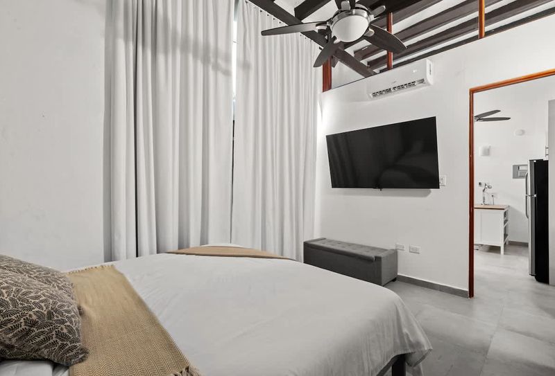 Enjoy the convenience of a flat-screen TV and efficient air conditioning, while the comfortable bed and sheer curtains create a tranquil retreat.