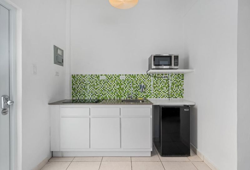 A clean, modern kitchenette with vibrant mosaic tiles. Perfect for a quick meal.
