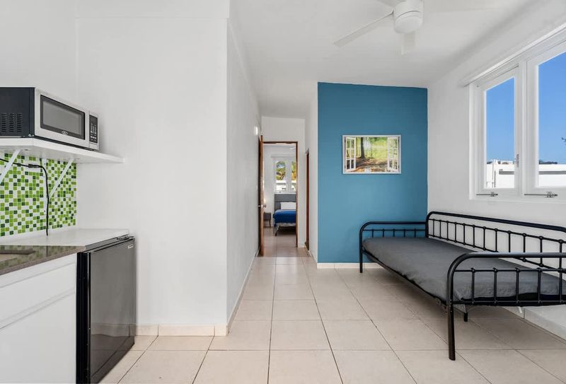 A well-lit common area with a TV and access to the bathroom. Simple and inviting.