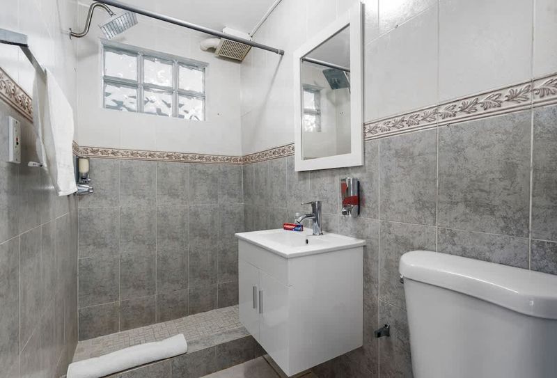 Sunset | Beach Stay 4 Enter into contemporary elegance with this immaculate bathroom featuring tiled walls and modern facilities.