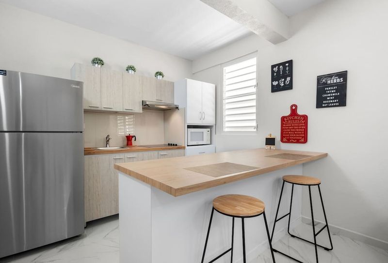 Gorgeous wood counter and modern stools. Eat−in kitchen.