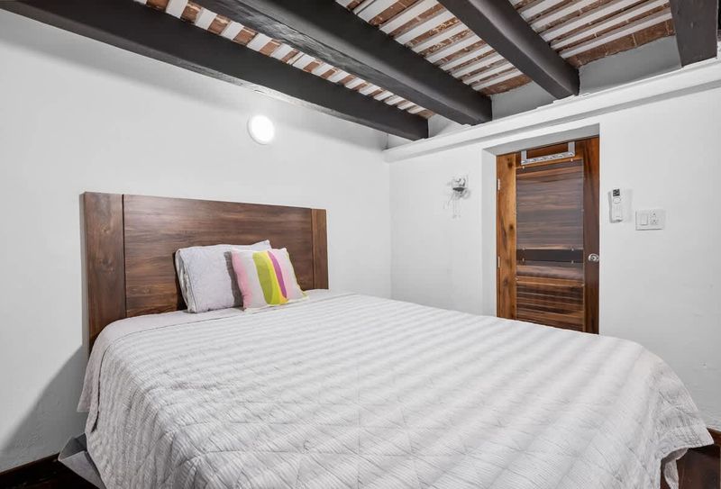 Restful sleep: Comfortable bed with a striking wooden headboard.