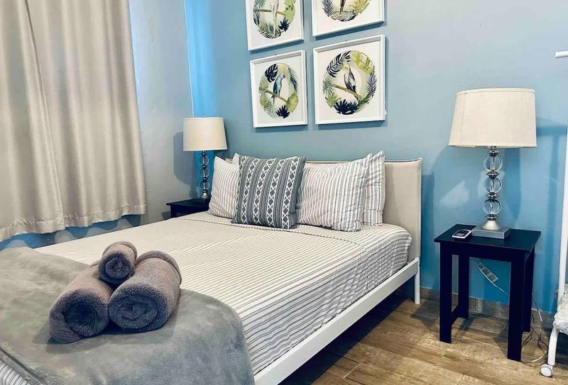 Spacious Eco Retreat | Solar-Powered 3 Drift into a restful sleep! Our spacious principal bedroom features a luxurious queen-size bed and an essential air conditioner for your ultimate comfort.