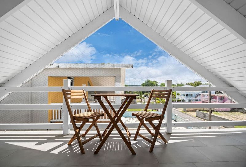 Rincón | Stay With Balcony 5 Perfect Balcony for Outdoor Dining. This balcony features a cozy table and chairs, creating an ideal setting for outdoor meals with a view.