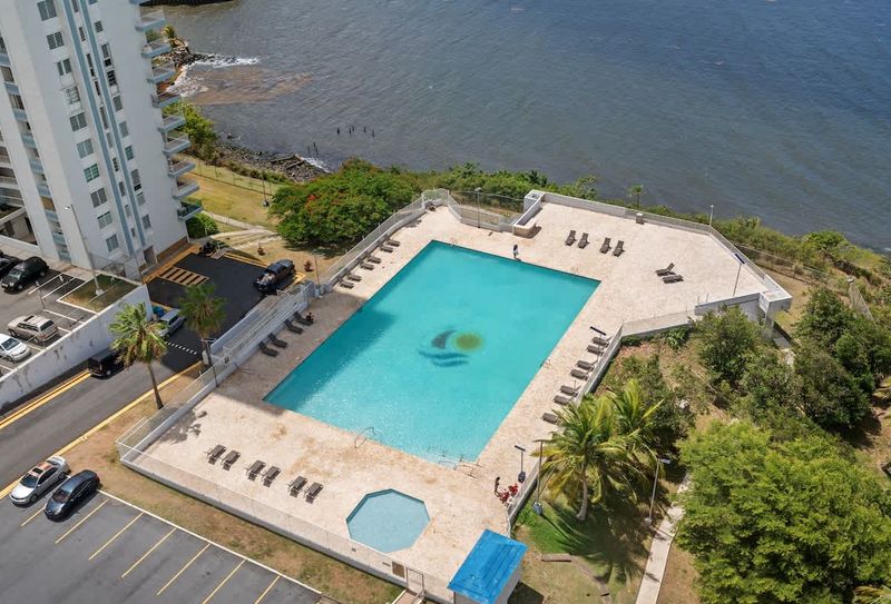 Experience the ultimate resort lifestyle! This incredible aerial view showcases our inviting pool, perfectly situated with the stunning backdrop of the tranquil bay and lush surroundings – your personal slice of paradise.