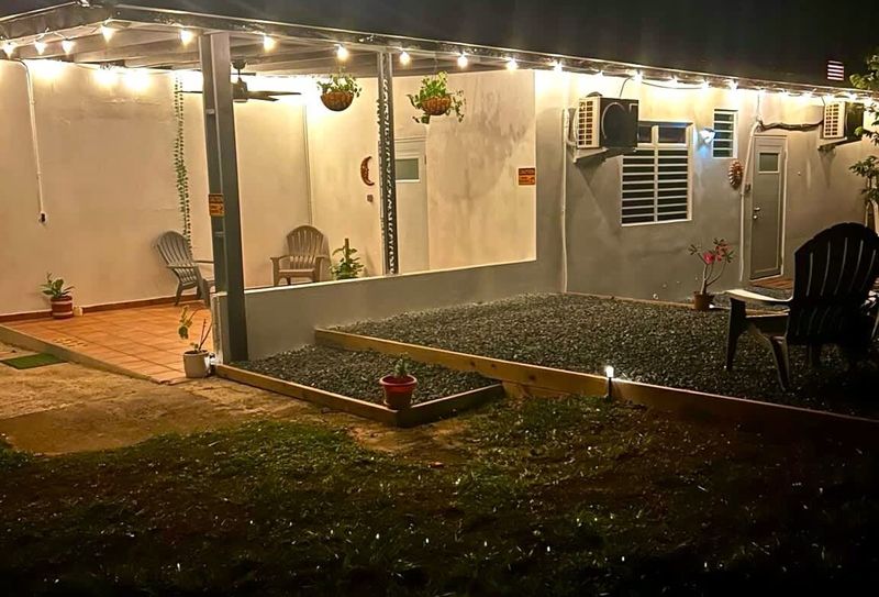 Charming night view of Luna Suite at Casa Natura, featuring warm patio lights, a cozy terrace, and peaceful outdoor seating. Perfect for unwinding under the stars in a serene, nature-filled setting.