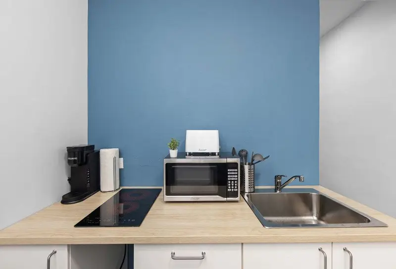 Kitchenette with induction cooktop, microwave and coffee maker