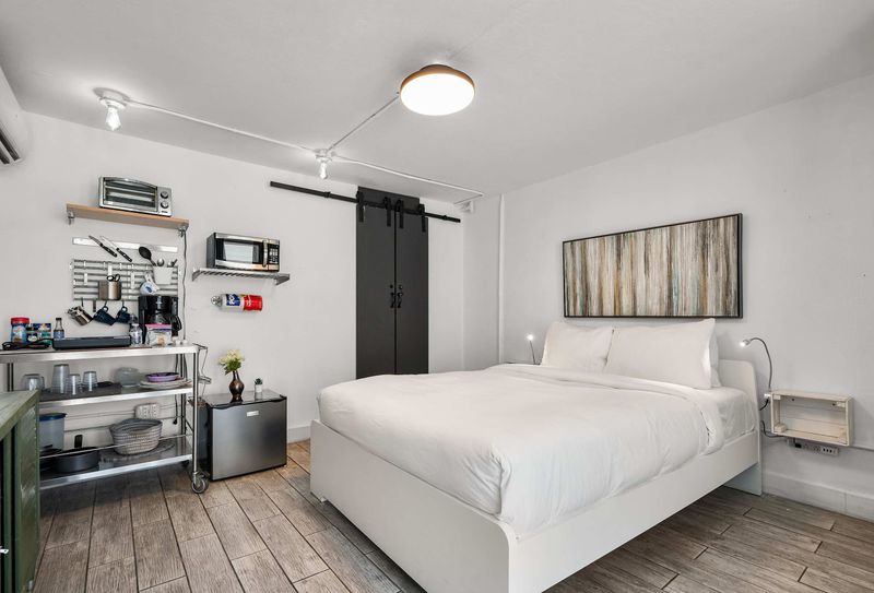 Wake up refreshed in a pristine double bed. Features stylish matte-black barn doors and minimalist design perfect for couples and digital nomads.
