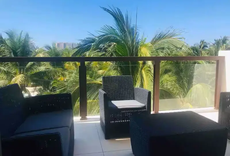 Balcony with outdoor seating among the palms