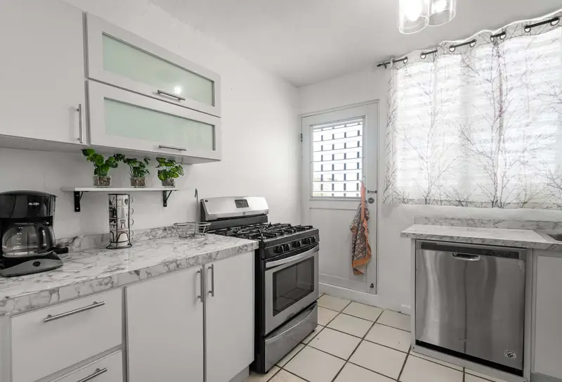 Kitchen with white cabinets, gas stove and dishwasher