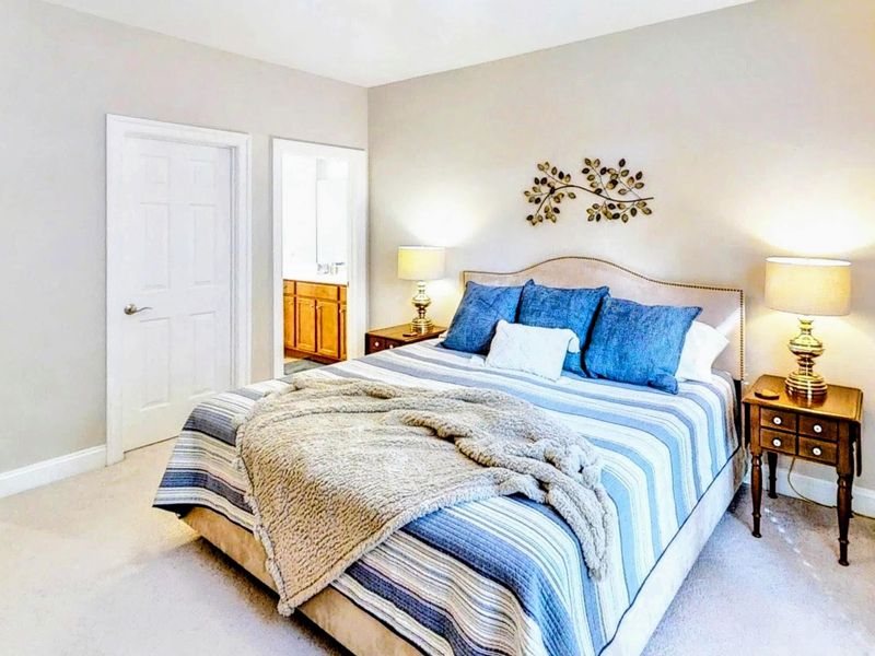 Relax in this beautifully designed bedroom featuring a plush queen bed, elegant decor, private patio access, and an en suite bathroom for added comfort and convenience.