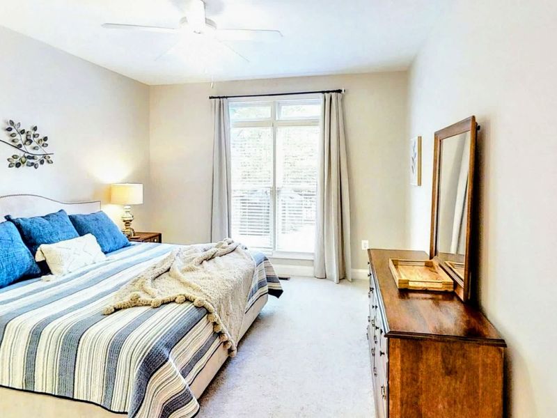 Relax in this beautifully designed bedroom featuring a plush queen bed, elegant decor, private patio access, and an en suite bathroom for added comfort and convenience.