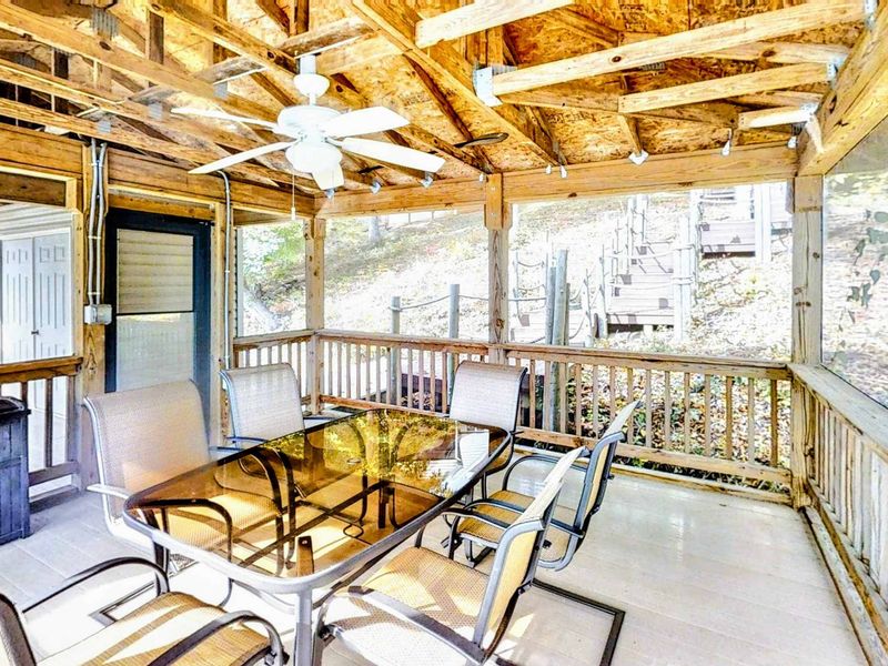 Dine and unwind in this charming covered seating area down at the dock, complete with a ceiling fan, comfortable seating, and beautiful lakeside views.