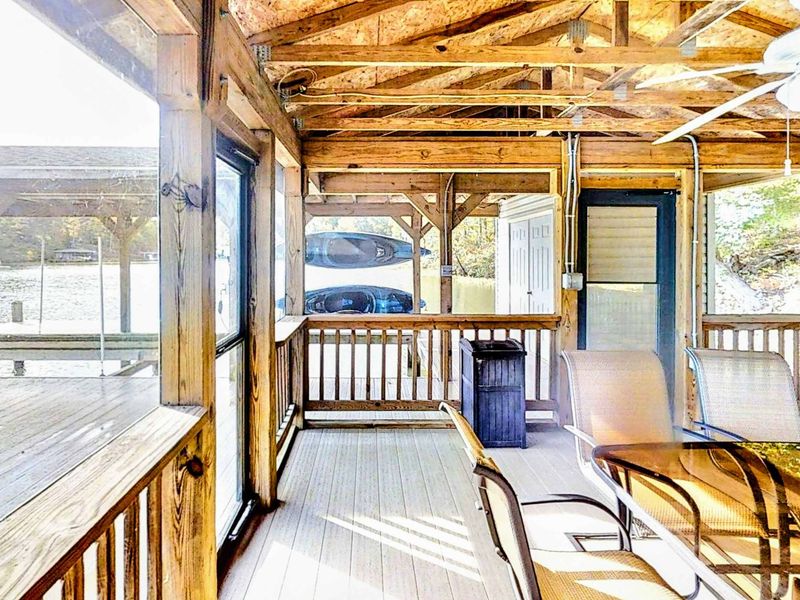 Dine and unwind in this charming covered seating area down at the dock, complete with a ceiling fan, comfortable seating, and beautiful lakeside views.