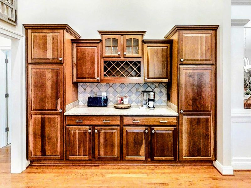 Beautifully built-in beverage station with ample cabinetry, granite countertops, and a convenient coffee maker—perfect for easy mornings and relaxed evenings.