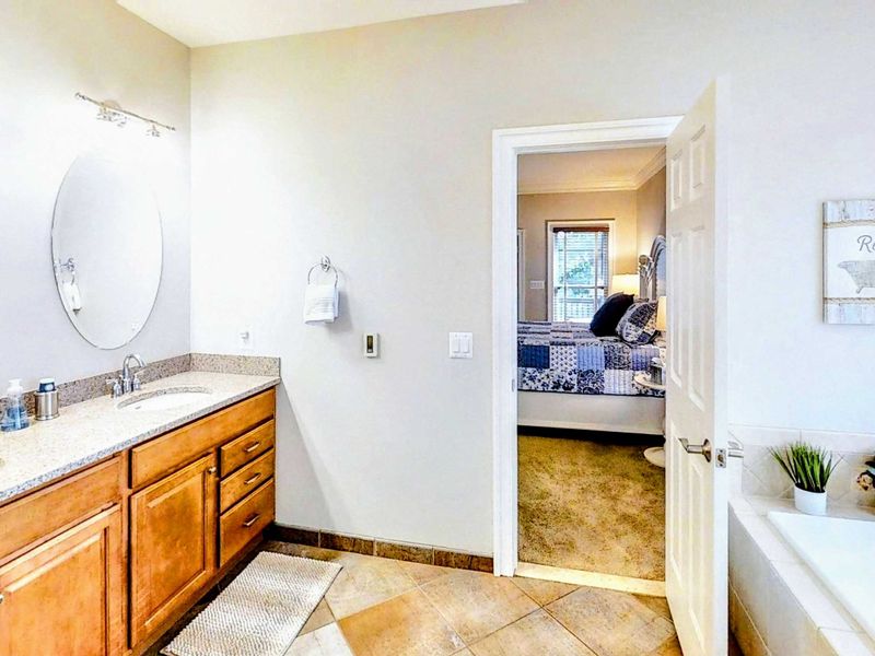 Indulge in the luxurious en suite bathroom of the king primary, featuring a dual vanity, a spacious walk-in shower, and a relaxing soaking tub for ultimate comfort.