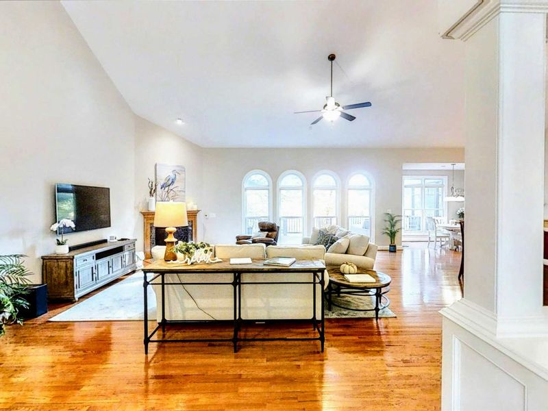 Indulge in a spacious and elegantly designed lakefront retreat, featuring cozy seating, high ceilings, and a seamless open floor plan perfect for gatherings.