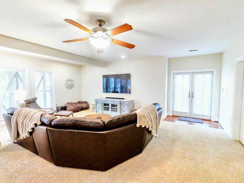 Enjoy the ultimate entertainment space with a spacious game room featuring a pool table, foosball, and a cozy lounge area with a large sectional and TV for movie nights.
