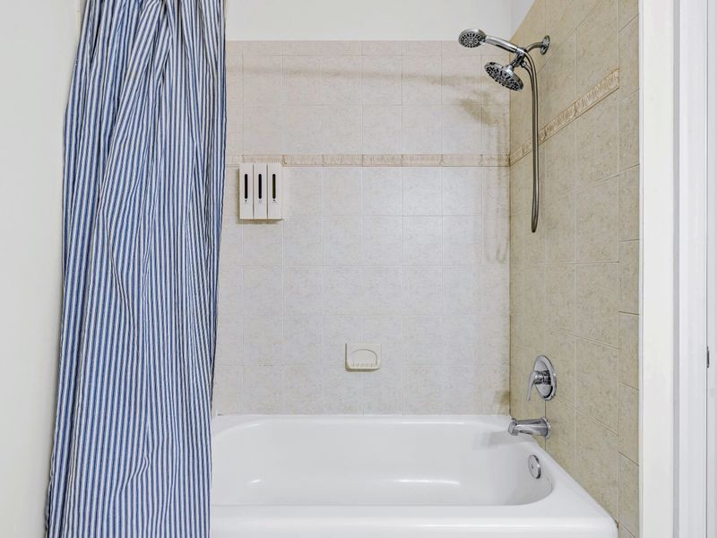 Clean and well-stocked full bath serving the lower-level rooms.