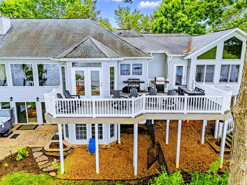 Multi-level decks step down toward the yard and the lake beyond.