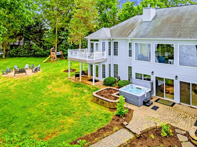The home's lakefront elevation, with green space rolling toward the water.