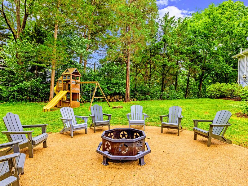 Adirondack chairs ring the fire pit just steps from the water.