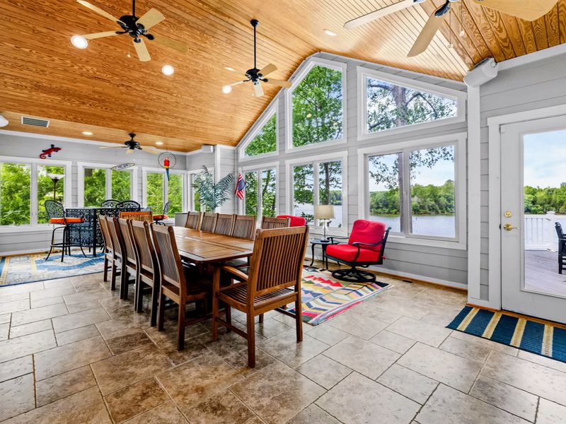 The sunroom's vaulted wood ceiling and wraparound windows make it the brightest seat in the house.