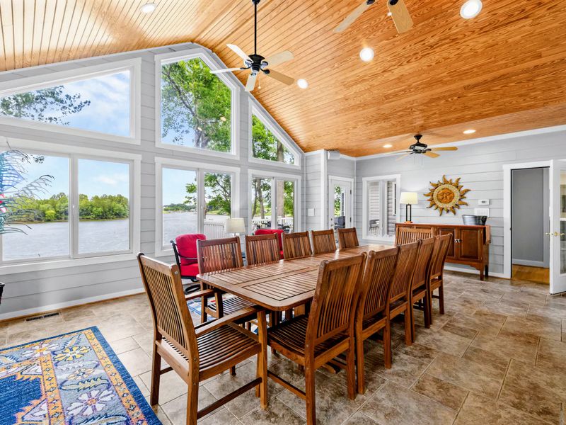 Walls of windows wrap the sunroom in light and water views from every angle.