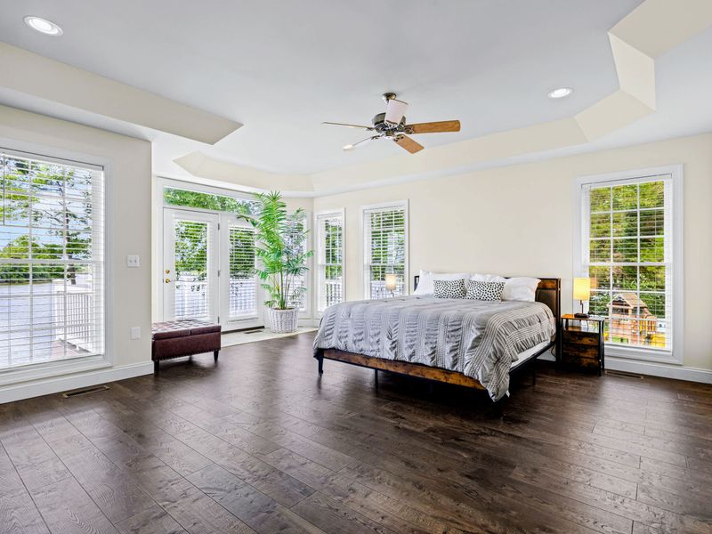 The primary suite: a king bed, private lake-view deck, and a spa-style ensuite.