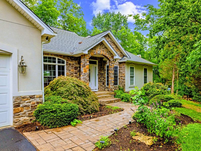 The covered front entry, framed by tidy landscaping and a calm, residential setting.