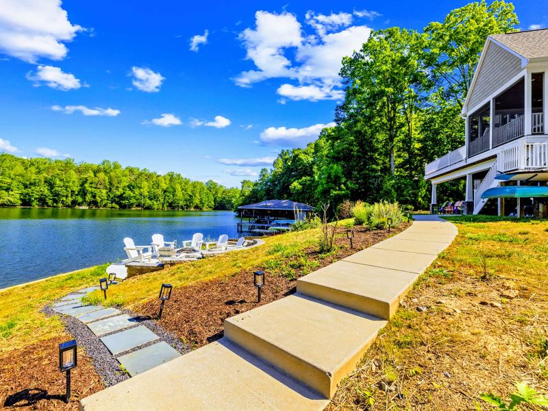 Waterfront Path - A landscaped walkway and stone steps lead down through the yard to the dock and the water's edge.